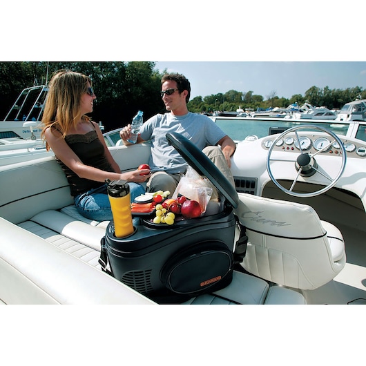 BLACKDECKER SBX300BCG portable cooler with open lid and assorted snacks on boat seat.