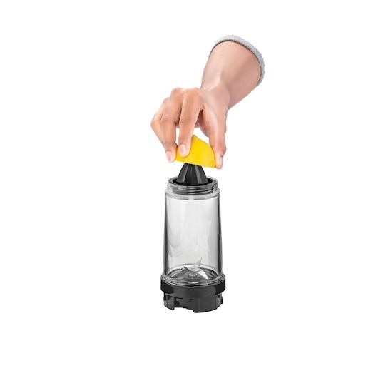 BLACKDECKER SBX300BCG blender cup with citrus juicer attachment, hand pressing lemon wedge, side angle, white background.