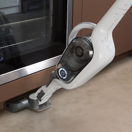 Photo of BLACKDECKER SVFV3250L cordless vacuum cleaner head cleaning under a kitchen oven.