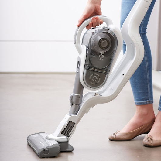 Photo of BLACKDECKER SVFV3250L cordless stick vacuum cleaner in use on light brown floor.