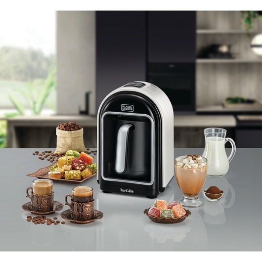 Photo of BLACK+DECKER TCM730 Turkish coffee maker on countertop with coffee cups, coffee beans, milk, and traditional sweets.