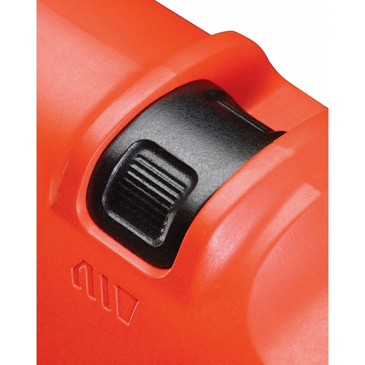 Close-up view of a black ridged adjustment dial set into an orange casing, part of a BLACK+DECKER device.
