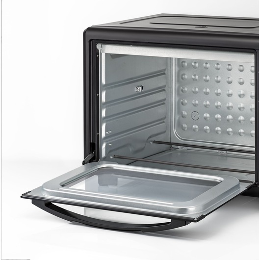 Close-up view of the interior of a BLACK+DECKER toaster oven with the front door open, showing the metal walls and tray area.