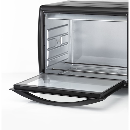 Close-up view of the interior of a BLACK+DECKER oven with the glass door open, showing an empty and clean metal oven chamber with a handle.