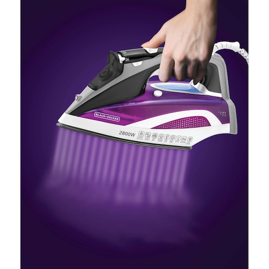 Photo of BLACK+DECKER X2250 purple steam iron in use, emitting steam, side view.