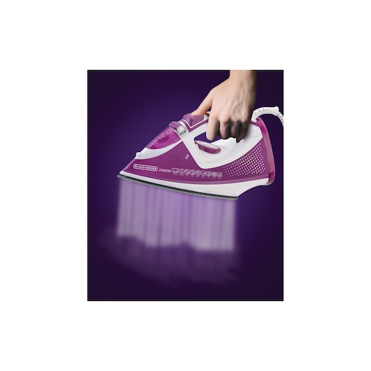BLACKDECKER X2450 steam iron in purple and white held in hand, front angle, with visible steam output.